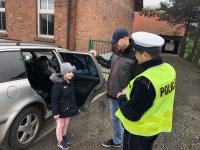 Policjant z raciborskiej drogówki kontroluje samochody przywożące przedszkolaków do przedszkola w Łańcach. Kontrole są pod kątem sprawdzenia czy dzieci są przewożone w fotelikach