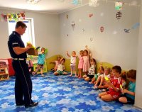 Raciborski policjant w trakcie spotkania z przedszkolakami omawia zasady bezpiecznego wypoczynku dzieci w trakcie wakacji