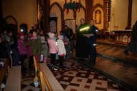 Dzieci od policjanta w kościele otrzymują elementy odblaskowe