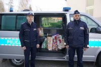 Raciborscy policjanci przed radiowozem wypełnionym torbami ze słodyczami do dzieci w Pogrzebieniu