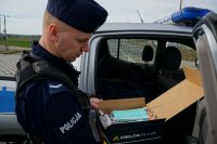 Policjant pokazuje pakiet ochronny