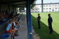 Dwaj policjanci przemawiają do grupy dzieci na spotkaniu w Krzanowicach