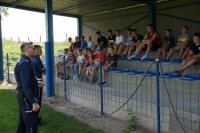 Dwaj policjanci przemawiają do grupy dzieci na spotkaniu w Krzanowicach