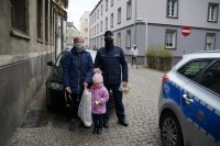 Policjant z babcią i dzieckiem dostają odblaski
