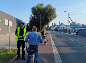 policjant z ruchu drogowego kontroluje trzeźwość rowerzysty