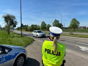 na zdjęciu policjantka z ruchu drogowego mierzy prędkość